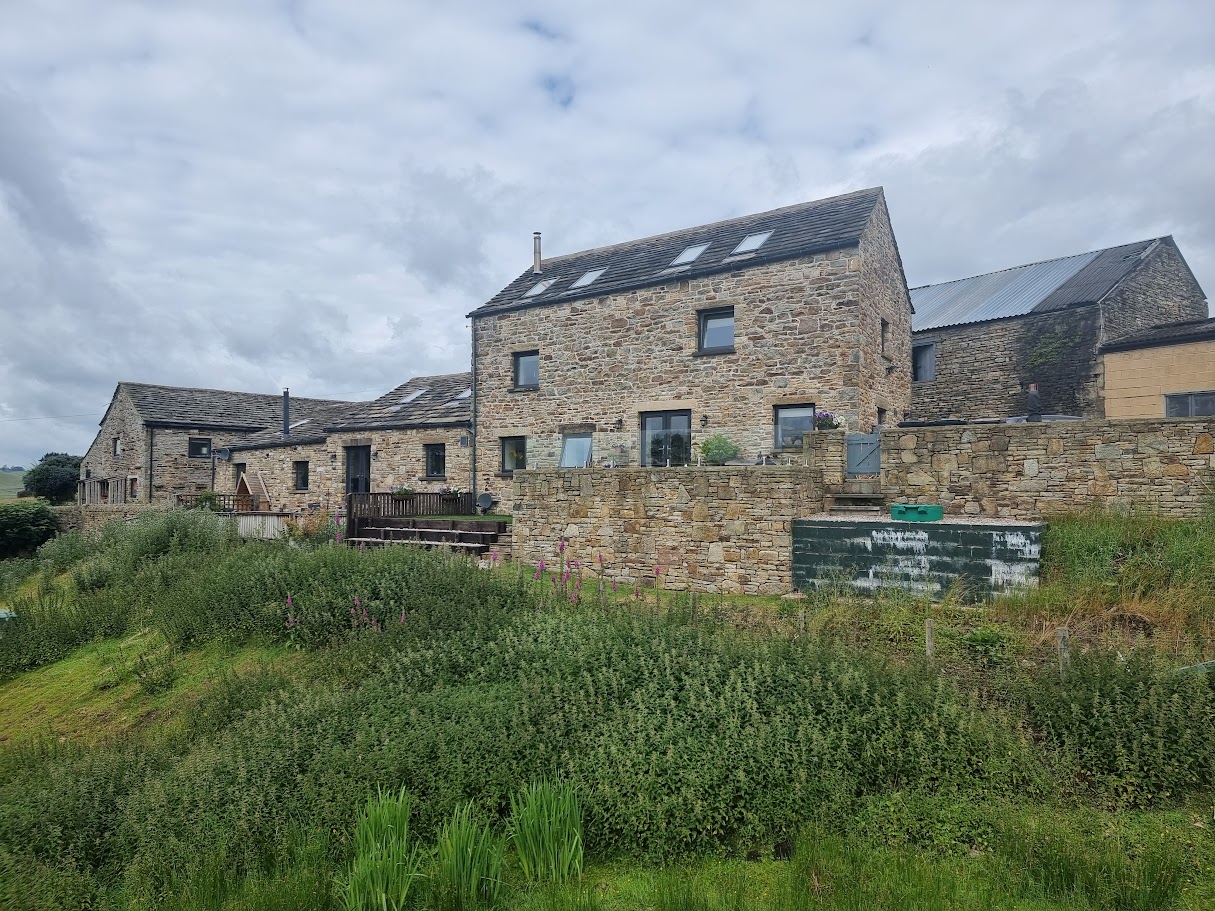 A frameless glass terrace at a New Mills farmyard conversion — further view of the completed installation