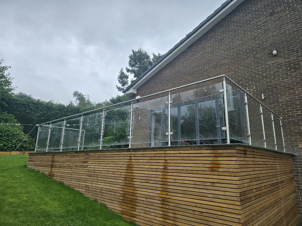 Stainless steel post and glass balustrade on a raised garden terrace — further view of the completed installation