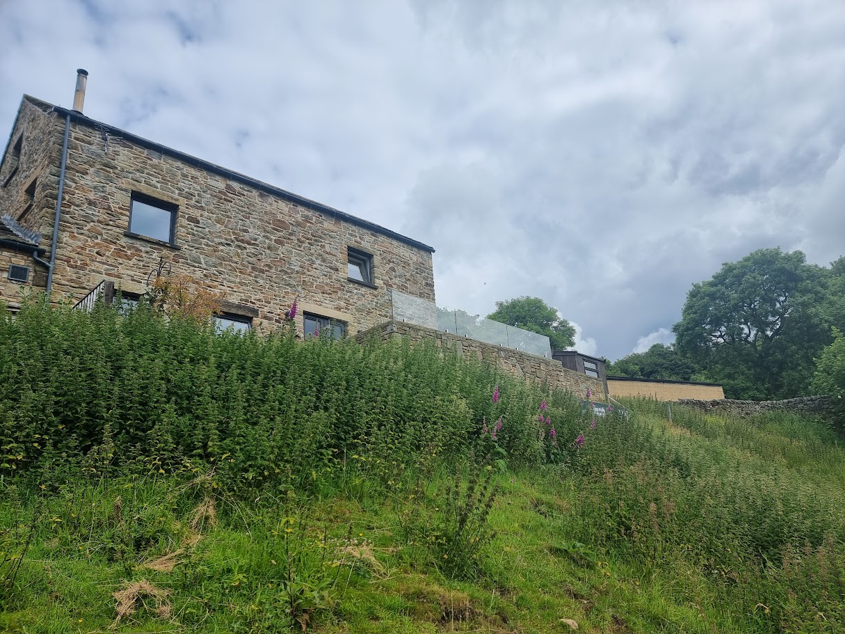 A frameless glass terrace at a New Mills farmyard conversion — further view of the completed installation