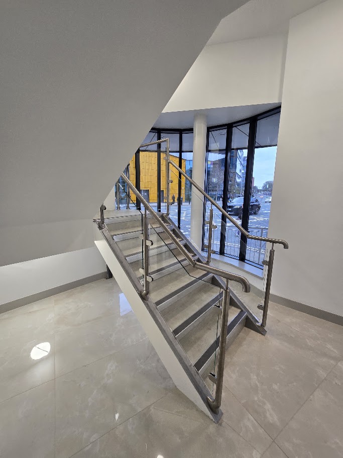 A post-and-glass commercial staircase at Madison House, Manchester — further view of the completed installation