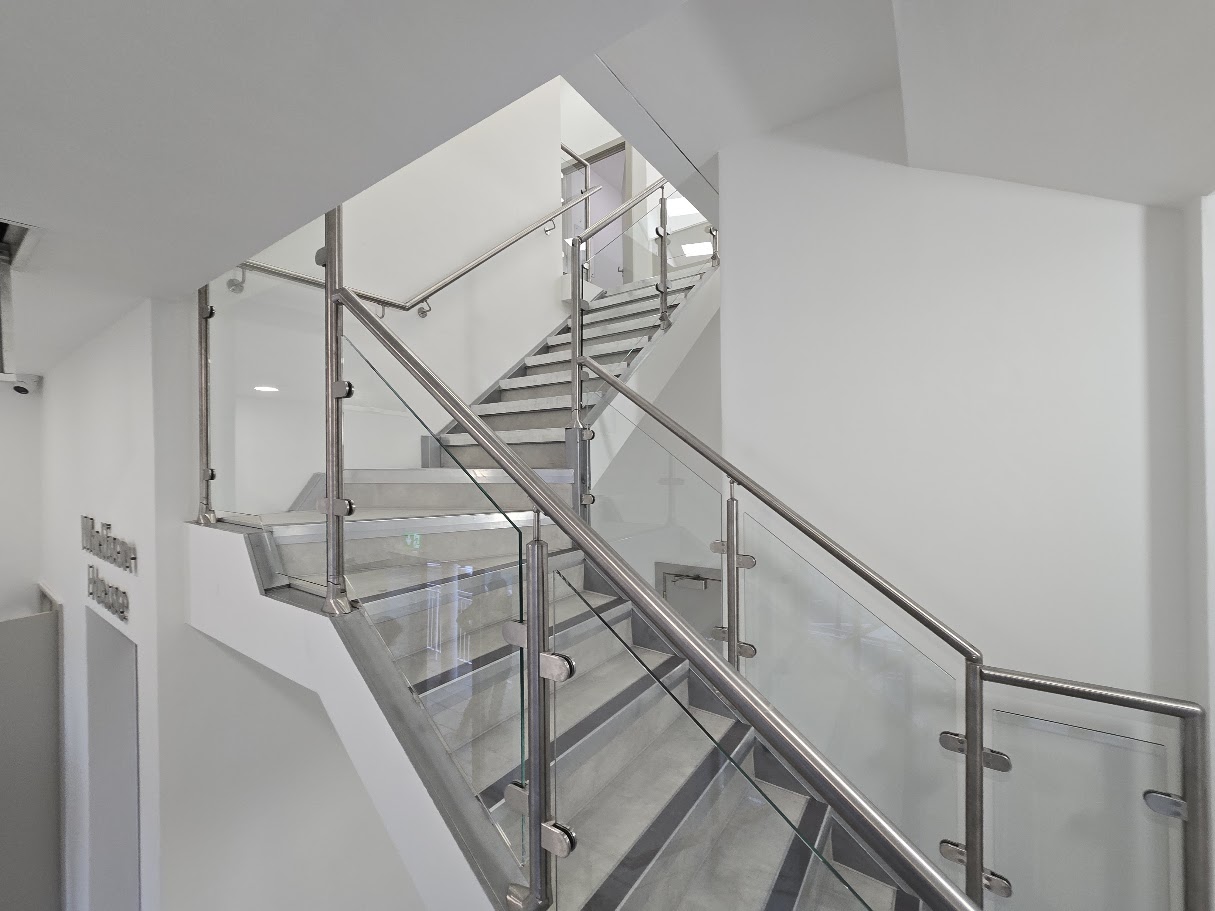 A post-and-glass commercial staircase at Madison House, Manchester — further view of the completed installation