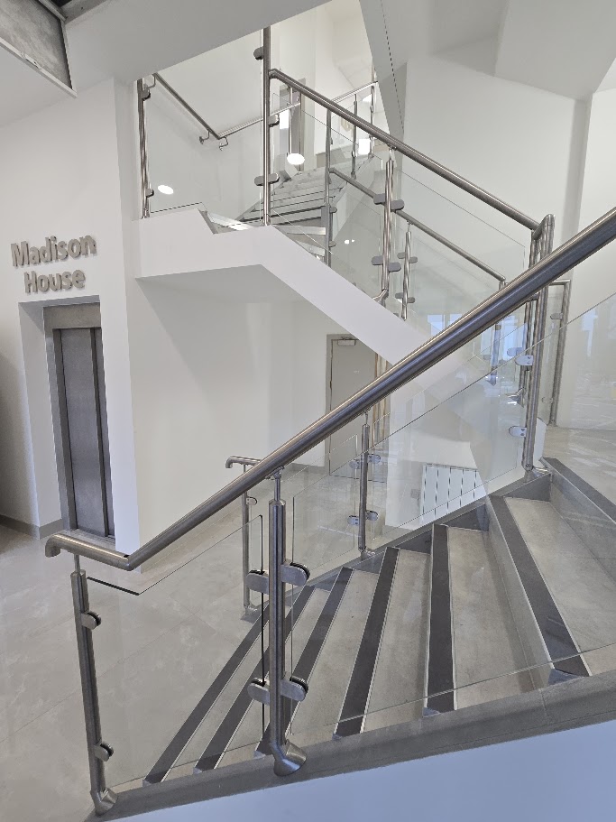 A post-and-glass commercial staircase at Madison House, Manchester — further view of the completed installation