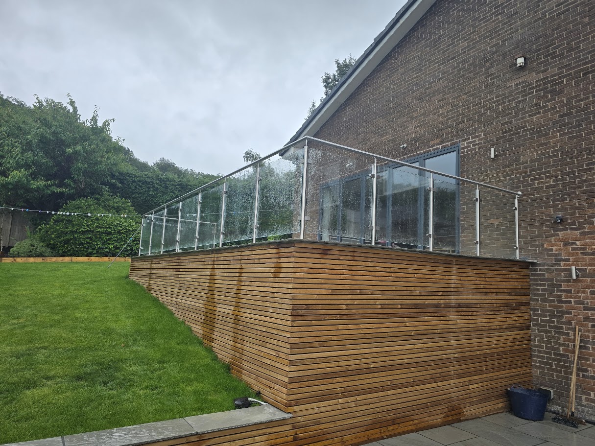 Stainless steel post and glass balustrade on a raised garden terrace — further view of the completed installation